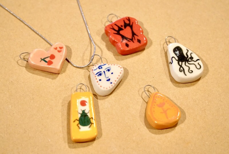 Collection of handmade ceramic charms from a charm making workshop in Irvine