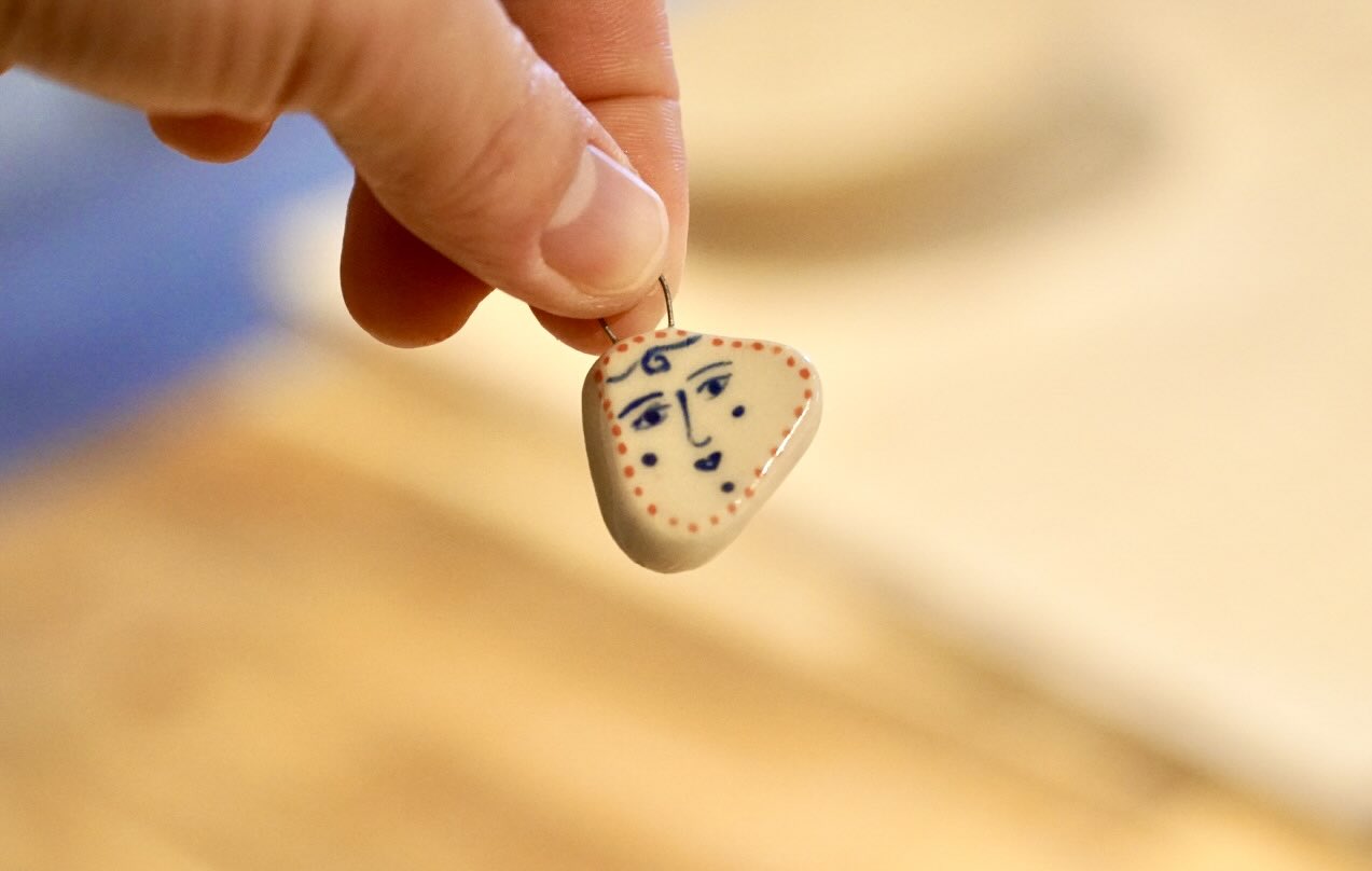 Hand holding a finished ceramic charm